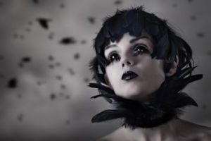 Crow girl with feather wig and black eyes, real contact lenses and makeup